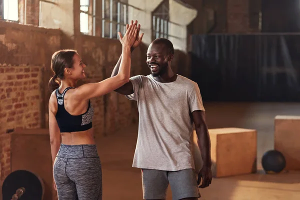 Esporte casal dando alta cinco após o treino de fitness no ginásio — Fotografia de Stock