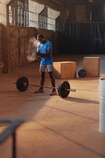 Hombre de deporte usando polvo de tiza de mano antes del entrenamiento en el gimnasio — Foto de Stock