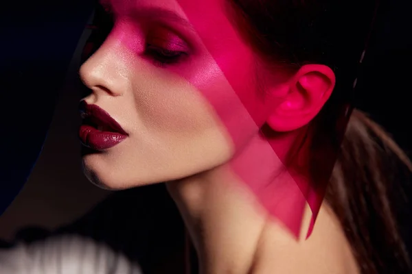Makeup beauty. Woman model with dark lipstick under pink light — Stock Photo, Image