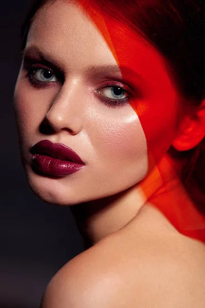 Maquillaje belleza. Modelo de mujer de moda con lápiz labial bajo luz roja —  Fotos de Stock