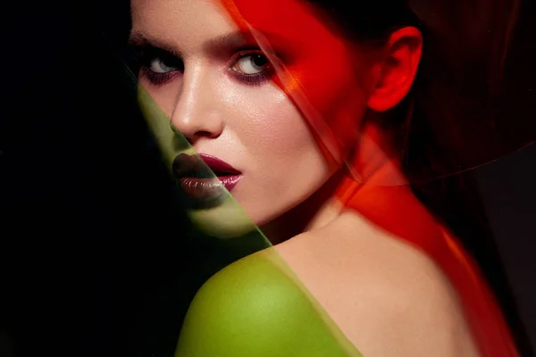 美容メイク。色光で赤い口紅を持つ女性モデルの顔 — ストック写真