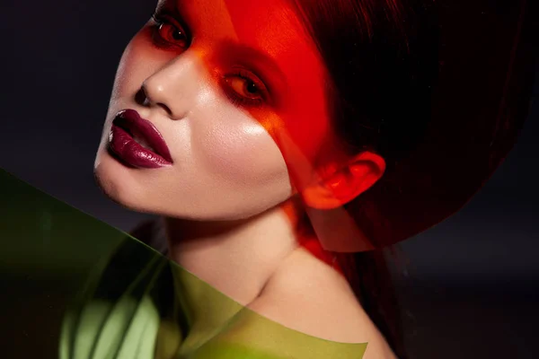 Μακιγιάζ ομορφιάς. Γυναίκα μοντέλο πρόσωπο με κόκκινο κραγιόν σε έγχρωμο φως — Φωτογραφία Αρχείου