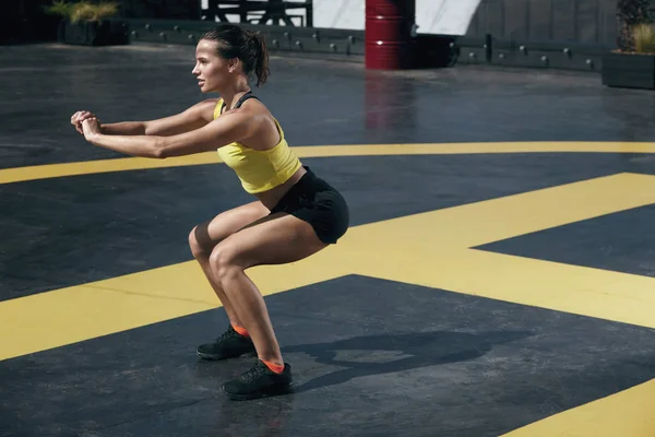 Mulher fitness exercício, fazendo agachamento exercício ao ar livre — Fotografia de Stock