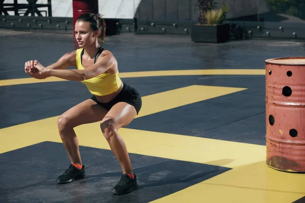 Mulher fitness exercício, fazendo agachamento exercício ao ar livre — Fotografia de Stock