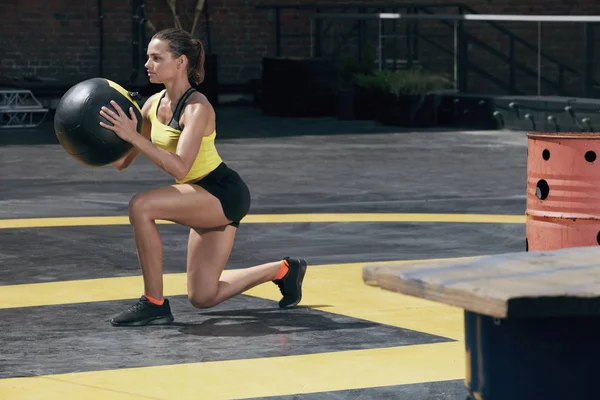 運動。屋外でメッドボールで脚のトレーニングをしているスポーツ女性 — ストック写真