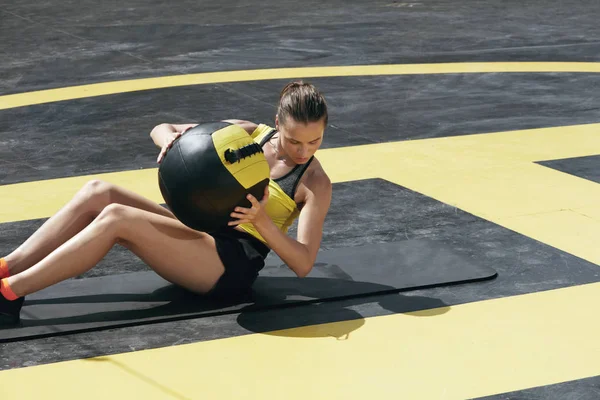 Treino. Mulher fitness fazendo exercícios abdominais com bola de medicina ao ar livre — Fotografia de Stock