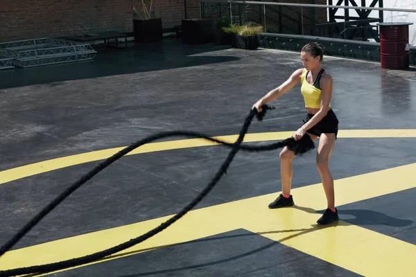 Спортивная женщина делает упражнения на канатах в спортзале — стоковое фото
