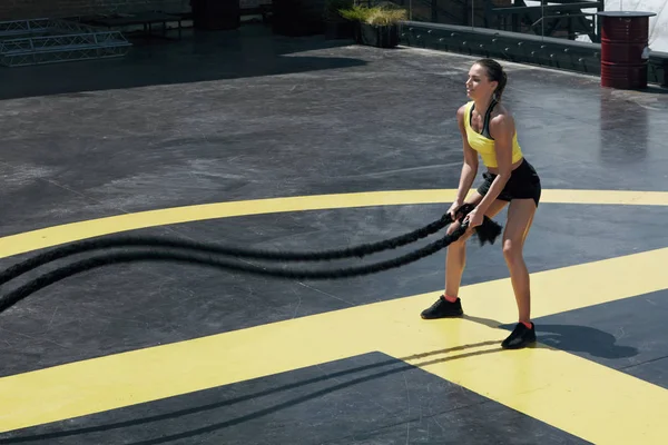 Спортивна жінка робить бойові мотузки тренування в тренажерному залі — стокове фото