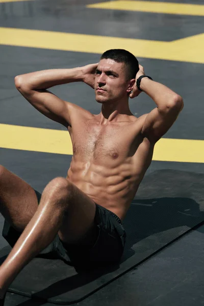 Sportmann macht Bauchmuskeltraining, Fitnesstraining auf der Straße — Stockfoto