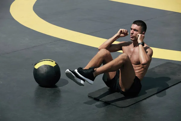 Fitnesstraining. Mann macht Bauchmuskeltraining auf der Straße — Stockfoto