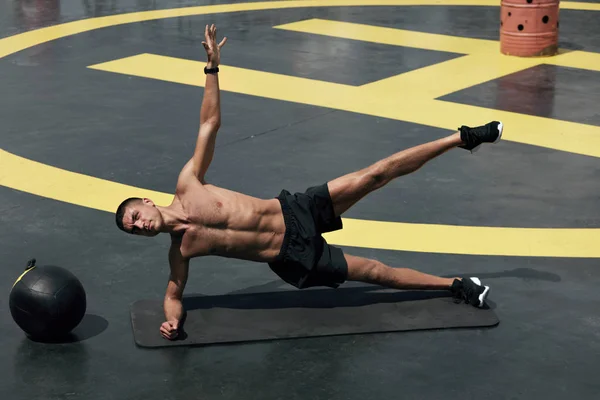 Спортсмен робить бічну дошку вправи, фітнес тренування в тренажерному залі — стокове фото