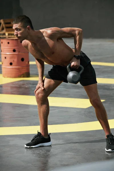 Спортивний чоловік робить вправи назад тренування з вагами на відкритому повітрі — стокове фото
