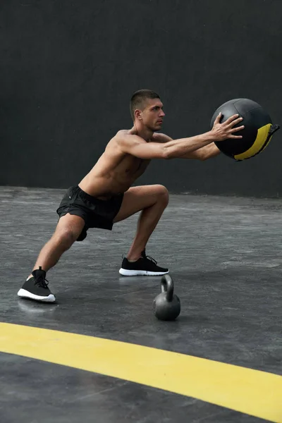 Sportler macht Ausfallübung mit Medizinball in Fitnessstudio — Stockfoto