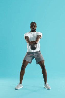 Egzersiz. Kettlebell salıncak egzersizi yapan adam, spor eğitimi