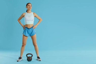 Spor giyim ve mavi spor ağırlığı uygun vücut ile Fitness kadın