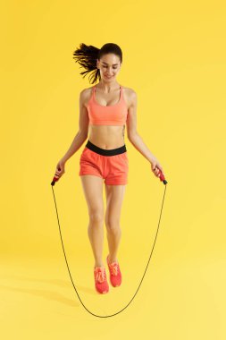 Fitness. Mutlu kadın ip atlama ile atlama egzersizleri yapıyor