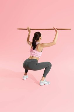 Egzersiz. Kadın egzersiz, stüdyoda vücut bar ile squats yapıyor