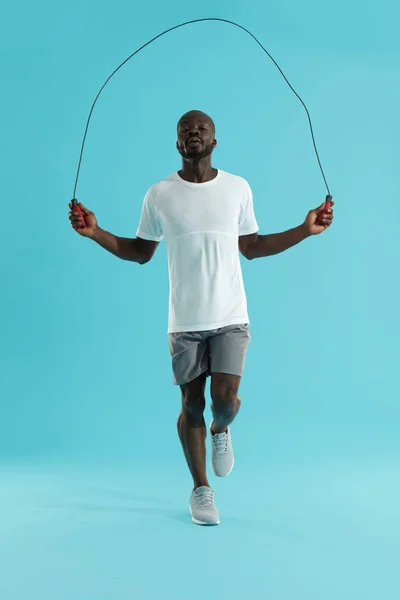 Workout. Sports man in sportswear exercising on jumping rope