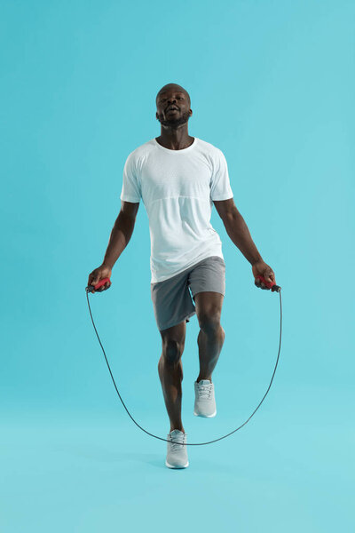 Workout. Sports man in sportswear exercising on jumping rope 