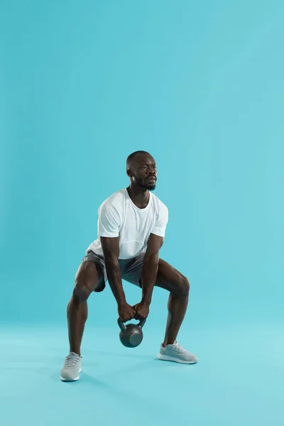 Entrenamiento físico. Hombre deportivo haciendo entrenamiento de sentadilla de kettlebell — Foto de Stock