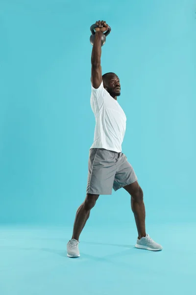 Ejercicio. Hombre haciendo entrenamiento de prensa de kettlebell, entrenamiento deportivo — Foto de Stock