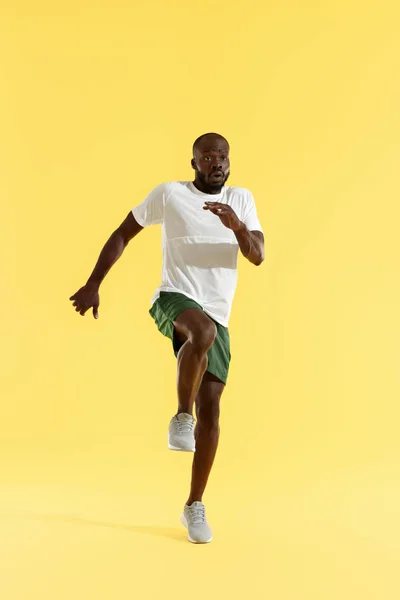 Entrenamiento. Hombre deportivo haciendo ejercicio, corriendo en el lugar, entrenamiento cardiovascular — Foto de Stock