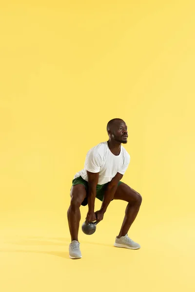 Entrenamiento físico. Hombre deportivo haciendo entrenamiento de sentadilla de kettlebell — Foto de Stock