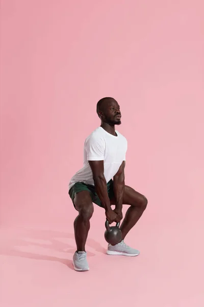 Entrenamiento físico. Hombre deportivo haciendo entrenamiento de sentadilla de kettlebell — Foto de Stock