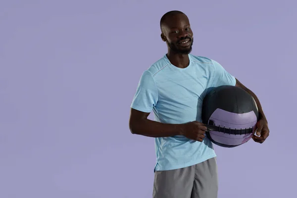 Усміхнений чорний чоловік у спортивному одязі з портретом студії медичного м'яча — стокове фото