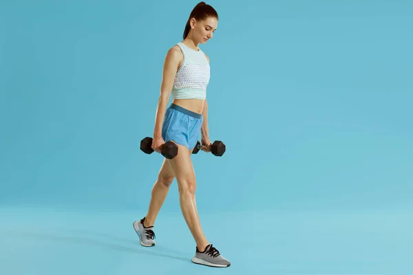 Spor fitness kadın stüdyoda spor ağırlığı ile egzersiz giymek — Stok fotoğraf