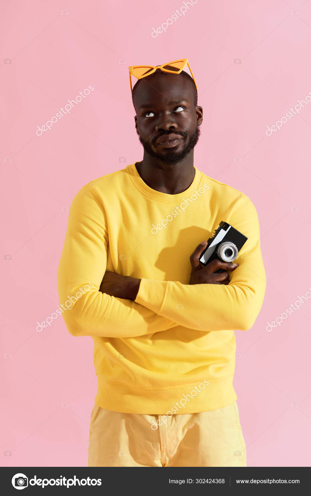 Hombre negro en ropa de moda amarilla con camara de fotos en rosa Foto de stock 302424368 puhhha
