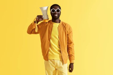 Sarı megafon ile gülümseyen siyah adam Moda portresi 