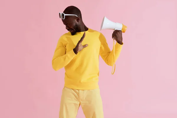 Hombre negro en ropa de moda con megáfono sobre fondo rosa — Foto de Stock