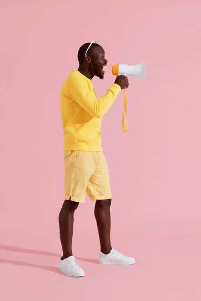 ¡Atención! Hombre negro gritando en megáfono sobre fondo rosa — Foto de Stock