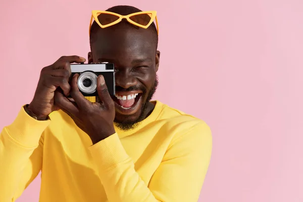 Fotógrafo de homem feliz com câmera de foto no fundo colorido — Fotografia de Stock