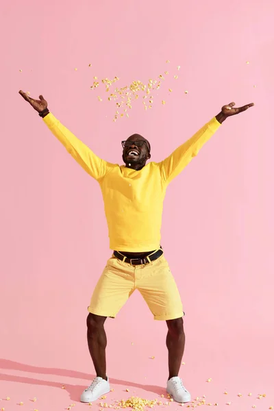 Hombre feliz en gafas de cine divertirse lanzando maíz pop en el aire — Foto de Stock