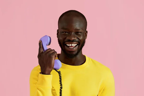 Lächelnder schwarzer Mann mit lila Telefon buntes Porträt — Stockfoto