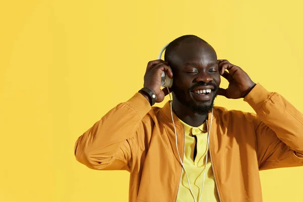音楽の肖像画を聴いて白いヘッドフォンで幸せな黒人男性 — ストック写真