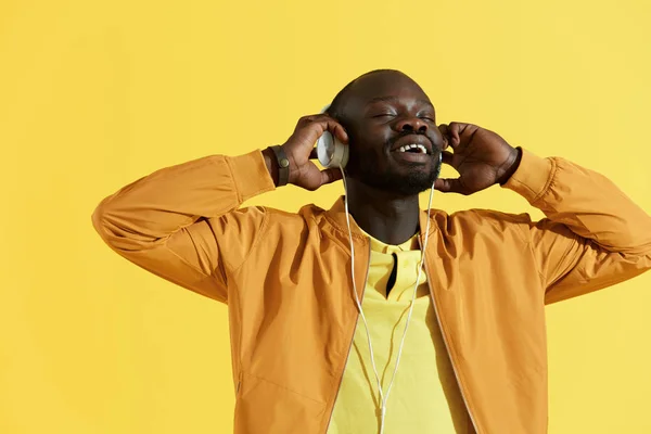 Hombre negro feliz en auriculares blancos escuchando retrato de música — Foto de Stock