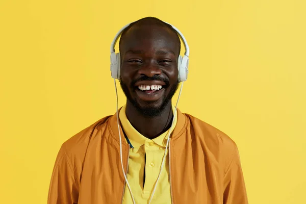 音楽の肖像画を聴いて白いヘッドフォンで幸せな黒人男性 — ストック写真