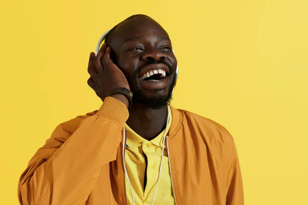 Hombre negro feliz en auriculares blancos escuchando retrato de música — Foto de Stock