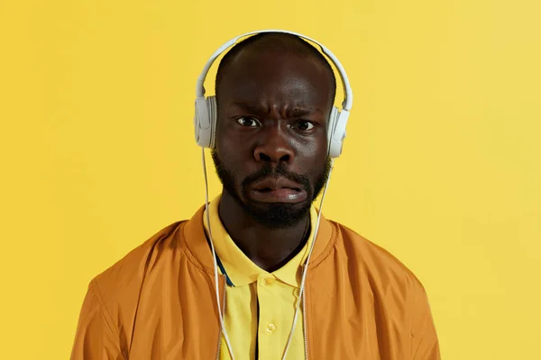 Man in white headphones listening music and making funny face — Stock Photo, Image