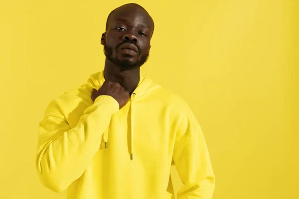 Fashion portrait black man in yellow hoodie on color background