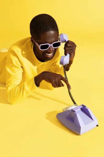黄色の紫色の携帯電話で話す幸せな男のカラフルな肖像画 — ストック写真