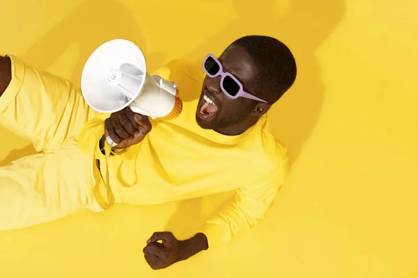 Hombre gritando en megáfono sobre retrato de fondo amarillo — Foto de Stock