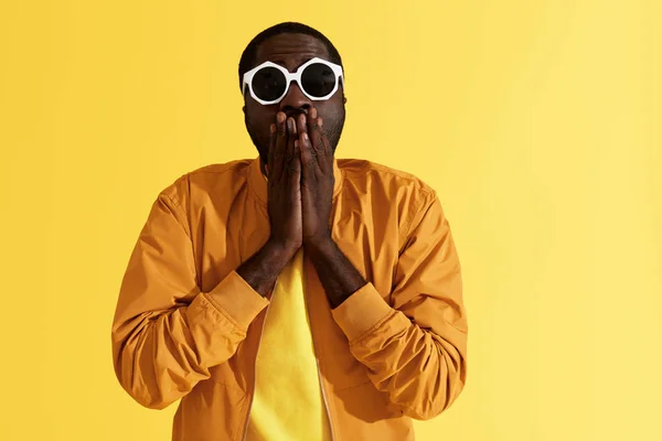 Surprise. Shocked man in fashion sunglasses on yellow background — Stock Photo, Image