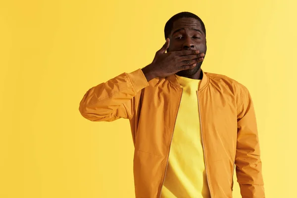 Sleepy tired black man yawning on yellow background portrait — Stock Photo, Image