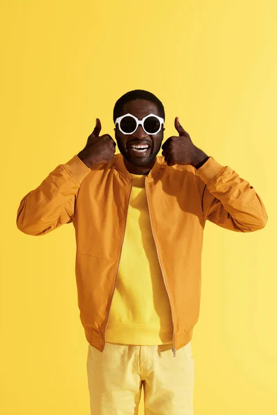 Smiling man in fashion sunglasses showing thumbs up portrait — Stock Photo, Image