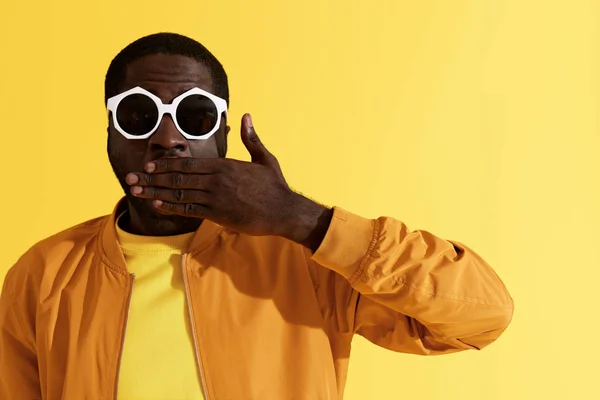 Surprise. Shocked man in fashion sunglasses on yellow background — Stock Photo, Image