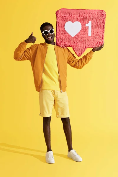 Lächelnder schwarzer Mann mit Ikone Pinata, der Daumen hoch zeigt — Stockfoto